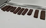 A row of bars consisting of chocolate-enrobe caramel slabs await evaluation in the Prototype Kitchen of the Mars Global Research and Development Hub.
