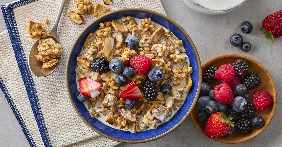 Table with bowl of granola and fruit