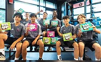 Kid soccer players sitting on bleachers, holding BEEUP snacks