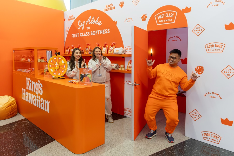 Man exiting orange dressing room as two women look on
