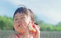 Cute girl eating baked good looking to the left