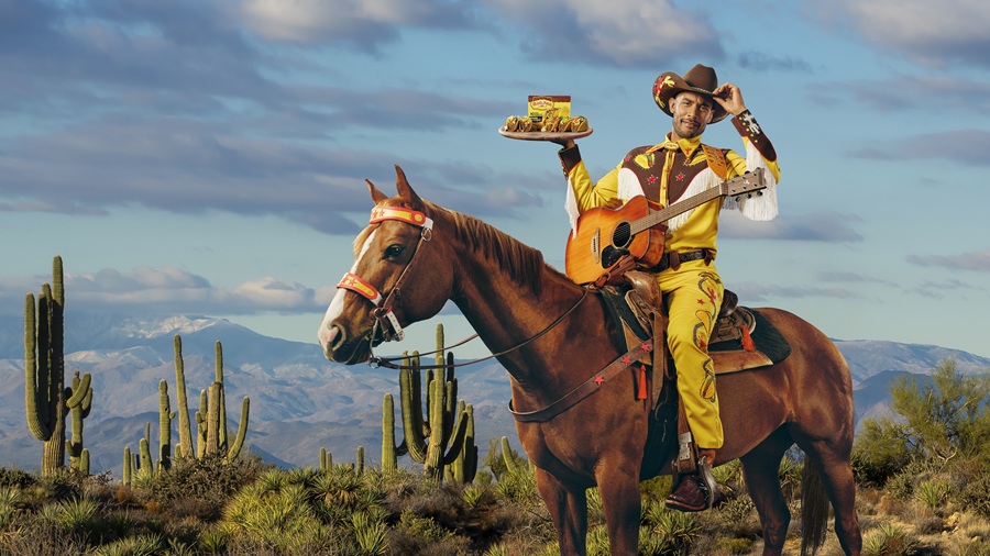 Cowboy on horse, holding a taco in the desert