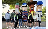 Sausage mascots and plain-dressed people standing outside