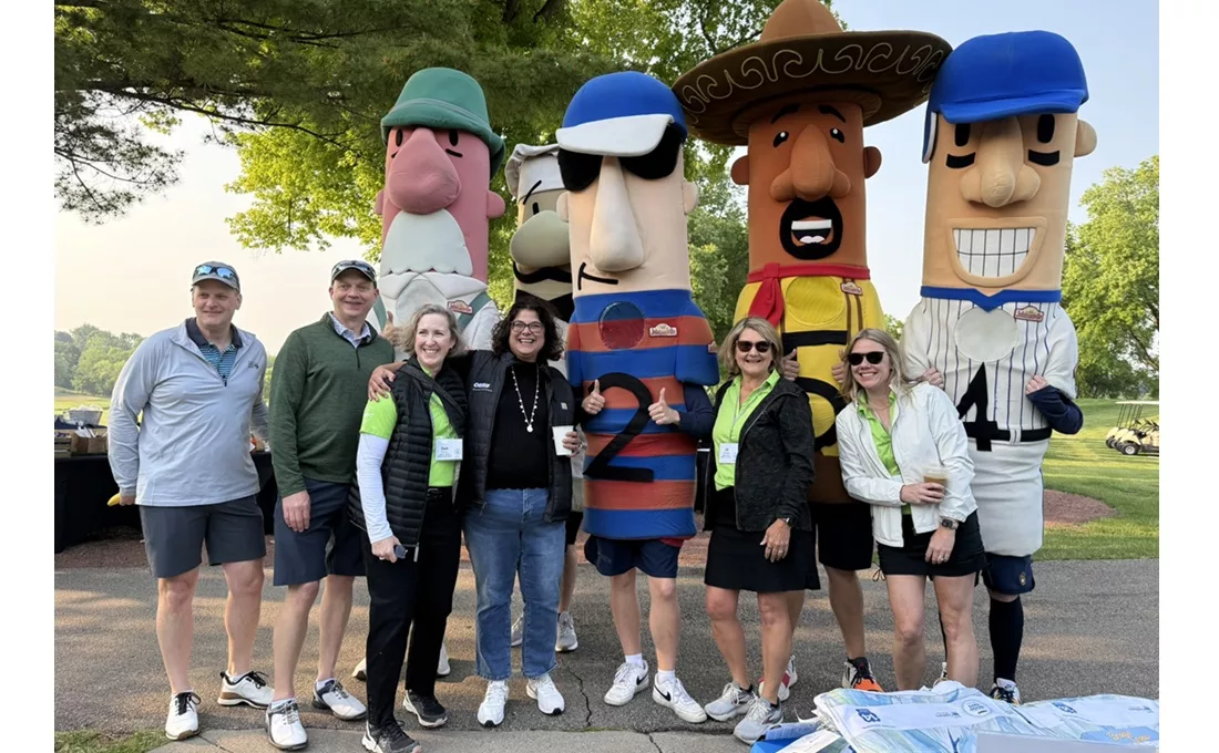 Sausage mascots and plain-dressed people standing outside