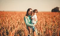 mother and son standing in sorghum field 