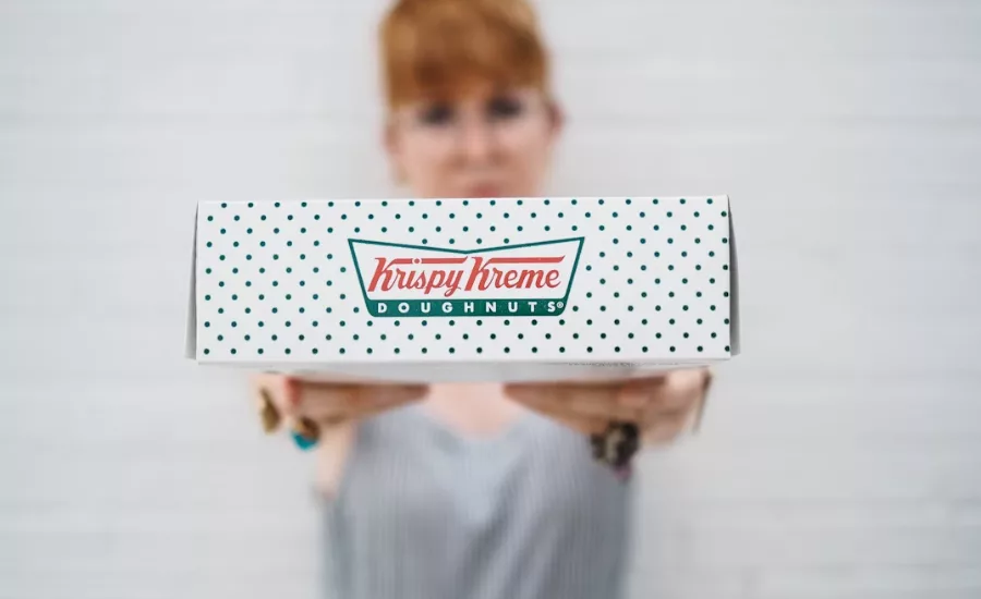 person holding krispy kreme box