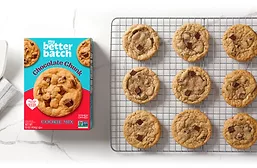 Box of cookie mix next to chocolate chips cooling