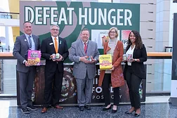 People in suits standing under DEFEAT HUNGER sign