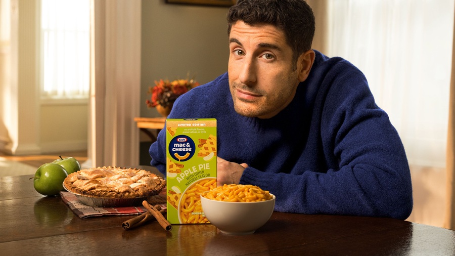 Actor Jason Biggs holding box of mac and cheese at table