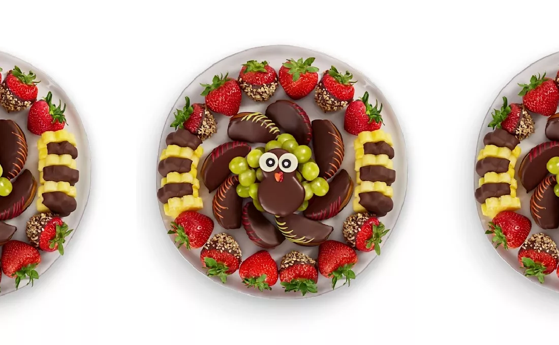 Platter of coated cookies, fruit, and other foods arranged to look like a turkey