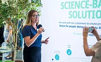 Woman in blue shirt speaking into microphone