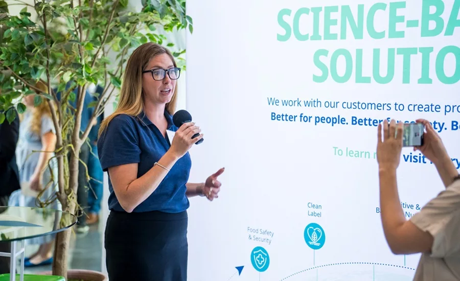 Woman in blue shirt speaking into microphone