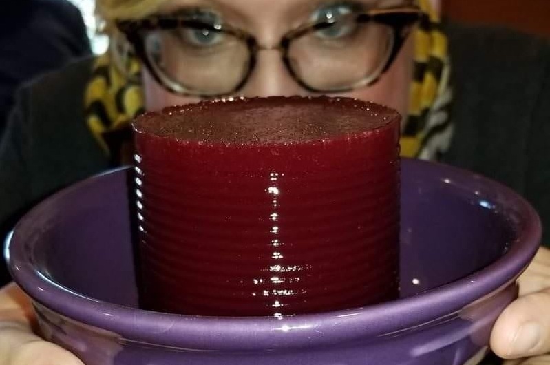 Woman in glasses holding bowl with cranberry monolith