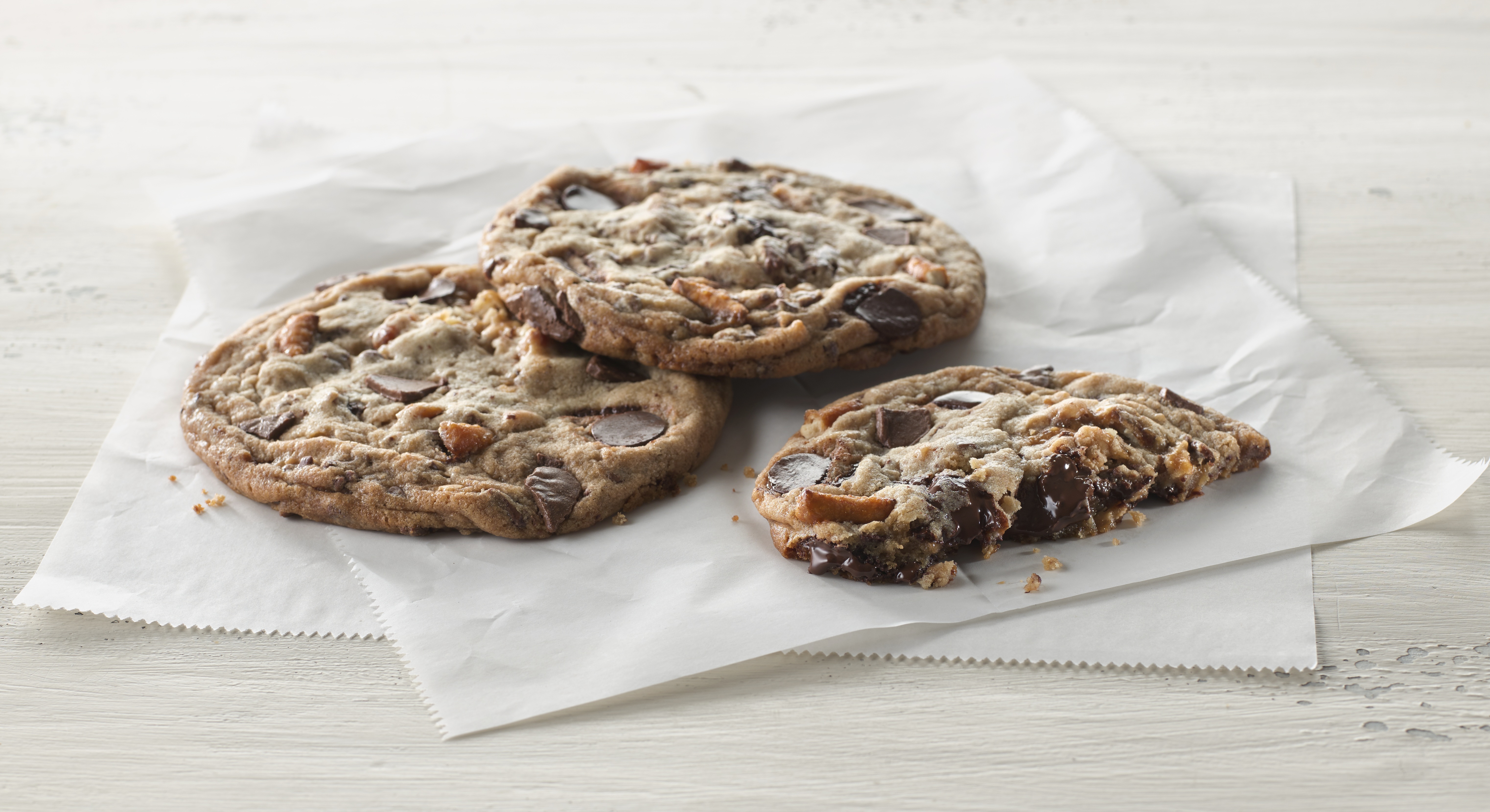 Three cookies on a napkin atop a table