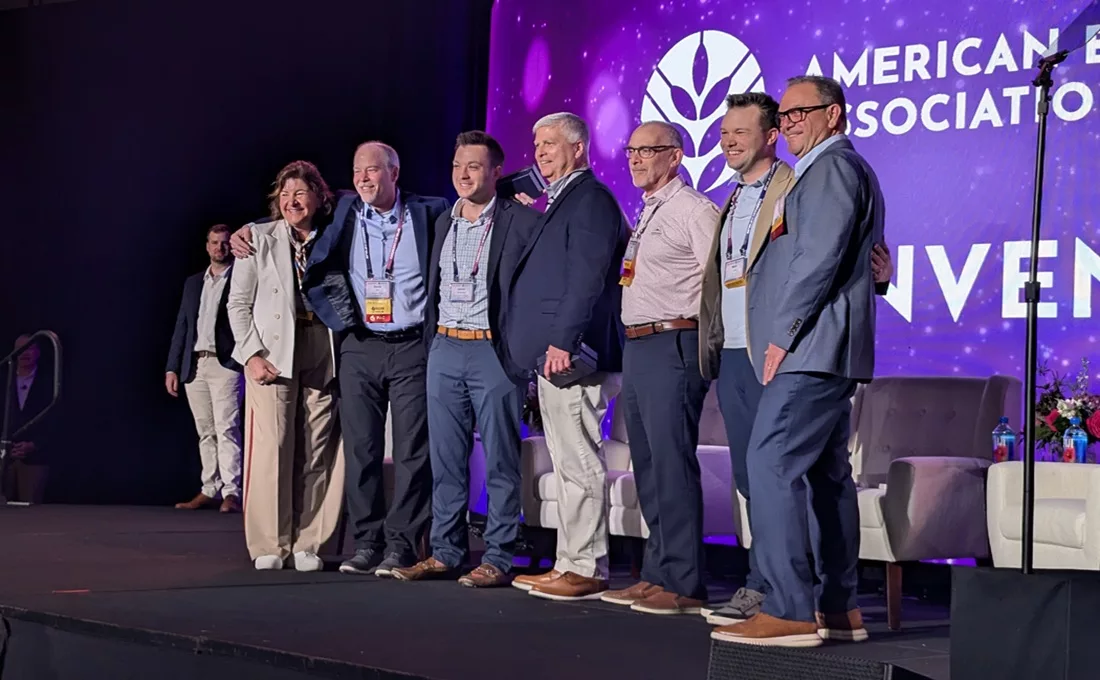 Several professionals standing on stage in front of purple background