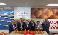 Puratos_UHT.jpg Group of men standing in front of table full of rolls