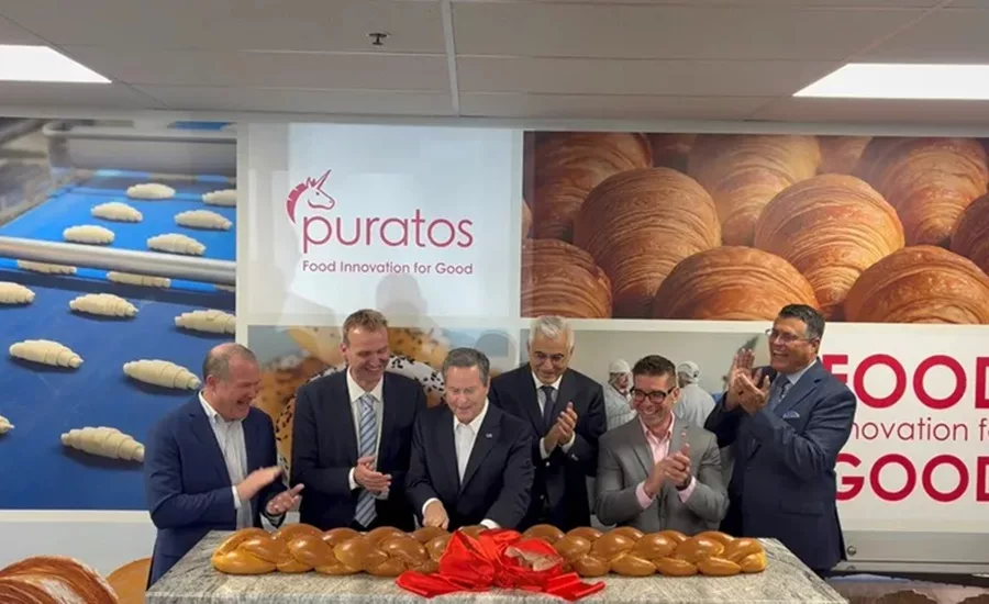 Group of men standing in front of table full of rolls