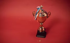 Trophy and ribbons on red background