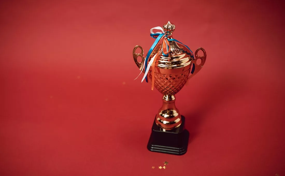 Trophy and ribbons on red background