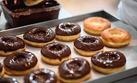 Baking sheet with chocolate glazed doughnuts