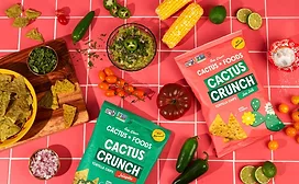 Colorful table covered with Cactus Crunch bags and different vegetables