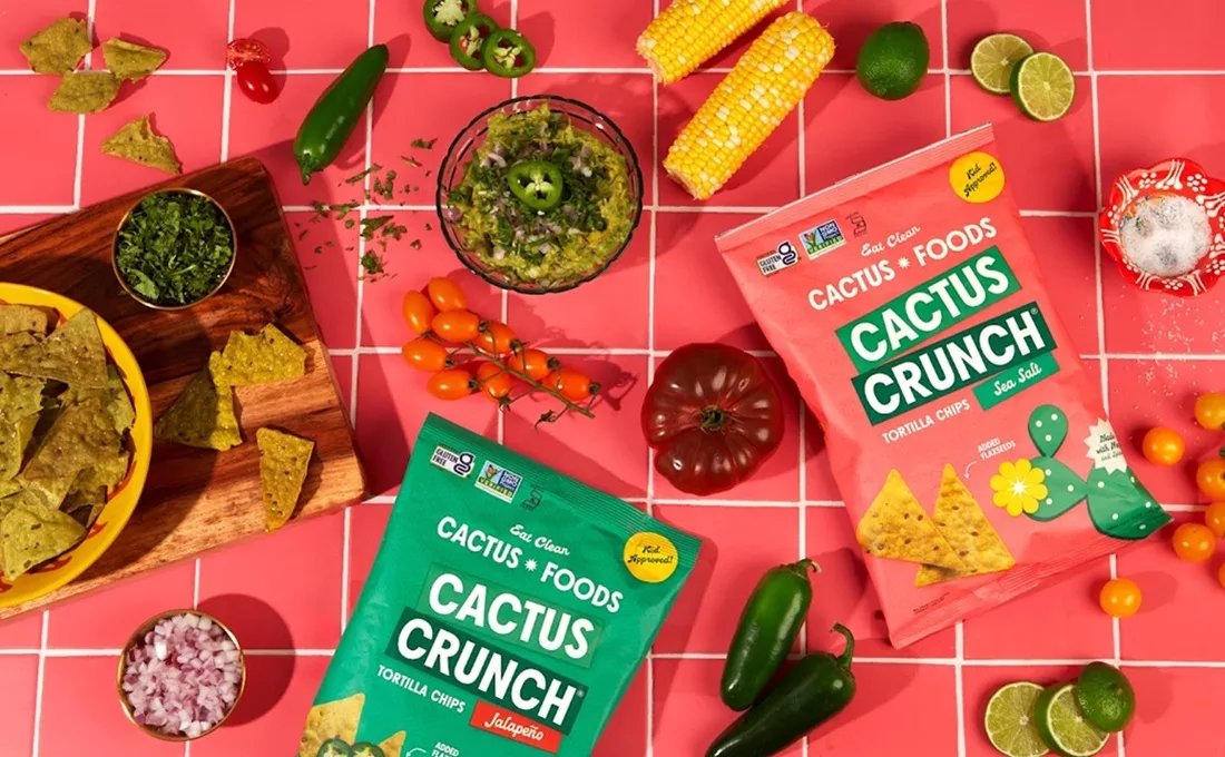 Colorful table covered with Cactus Crunch bags and different vegetables