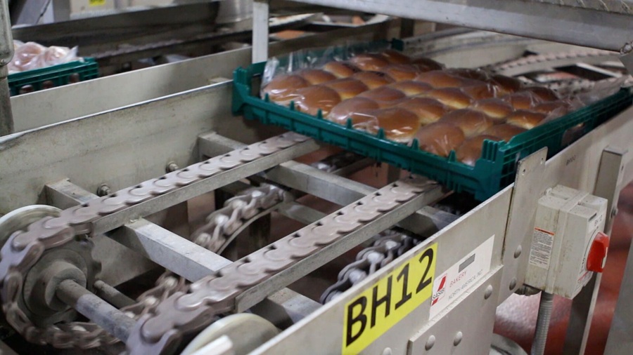 Reusable tray full of buns moving through system
