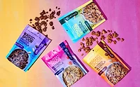 Four pouches of Magic Spoon granola over multicolored background