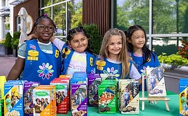 Group of young girls in uniform selling Girl Scout Cookies