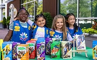 GSUSA_lead.jpg Group of young girls in uniform selling Girl Scout Cookies
