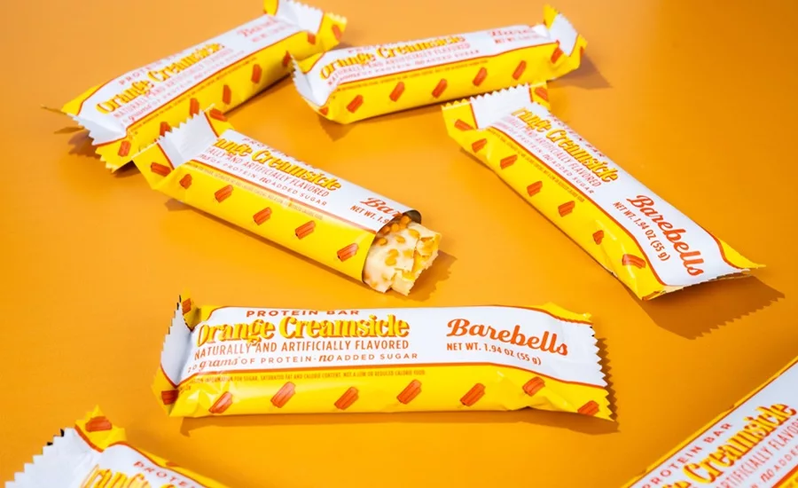Several Barebells Orange Creamsicle bars on orange background