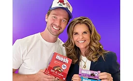 Patrick Schwarzenegger and Maria Shriver holding Mosh bars
