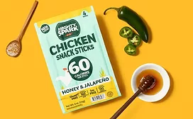 Pouch of Mighty Spark chicken sticks on yellow background