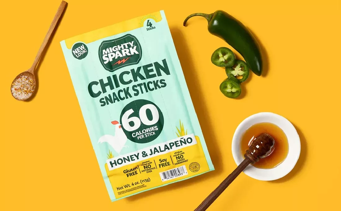 Pouch of Mighty Spark chicken sticks on yellow background