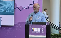 IBIE growth.jpg Bald, bearded white man at IBIE podium