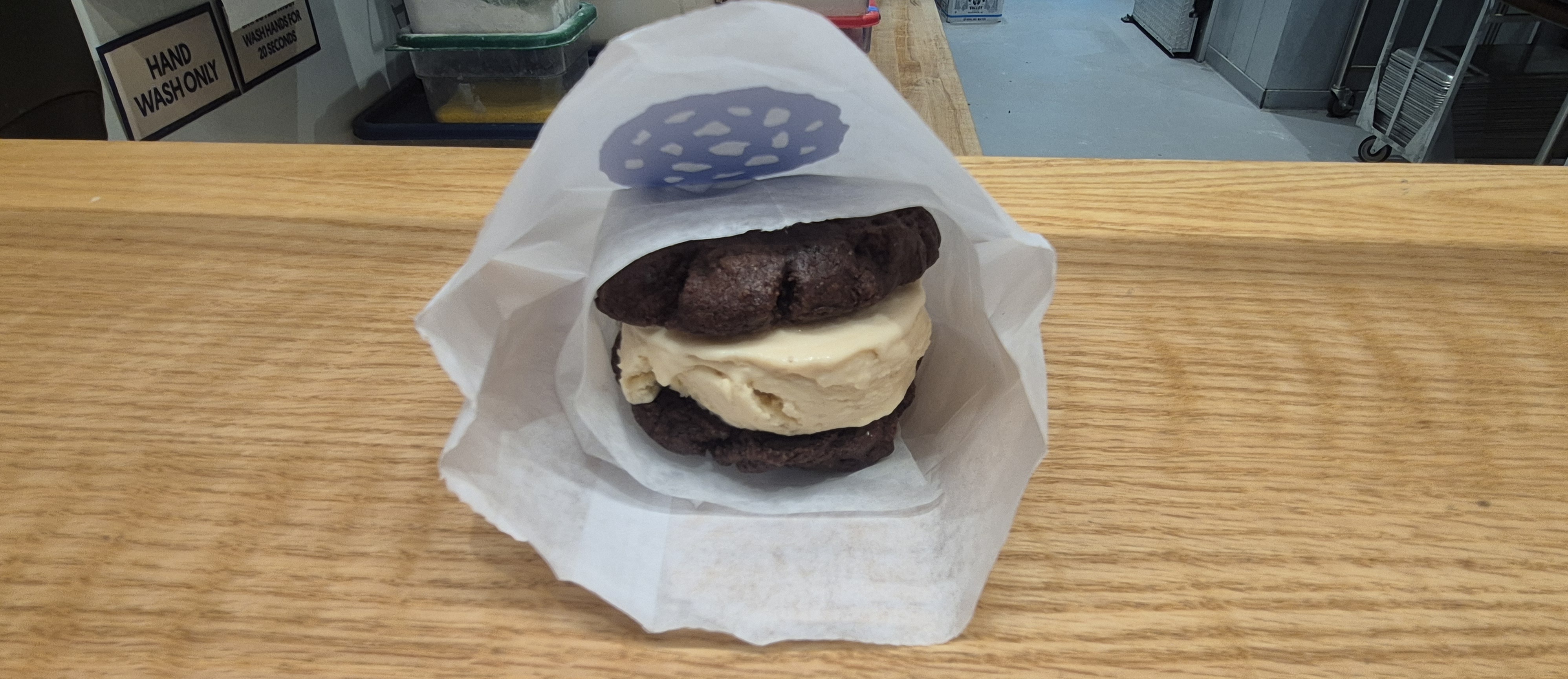 Ice cream sandwich made with chocolate cookies in a bag on a wooden table