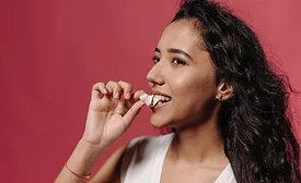 woman eating small piece of candy generic