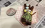 The company’s signature Voodoo Doll is a raised doughnut filled with raspberry jelly, topped with chocolate icing, and a pretzel-stick pin.