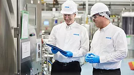 Two men in hard hats in food processing environment