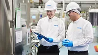 Two men in hard hats in food processing environment Two men in hard hats in food processing environment