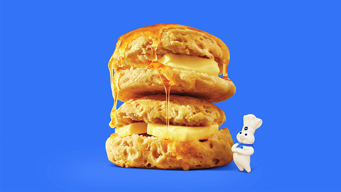 the Pillsbury Doughboy (real name: Poppin' Fresh) alongside biscuits with butter and honey