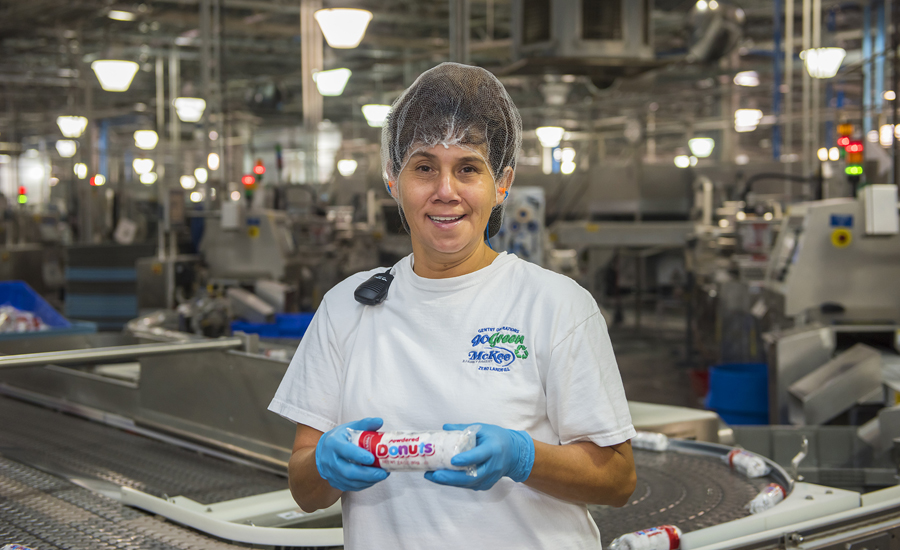 factory worker holding donuts