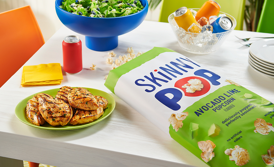 skinny pop, salad and chicken on a table