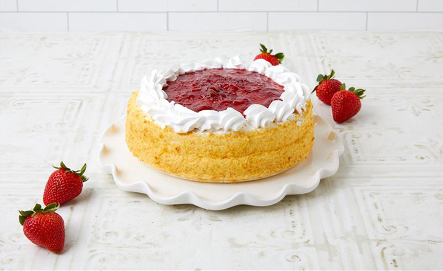 Plated cake with whipped cream and strawberries