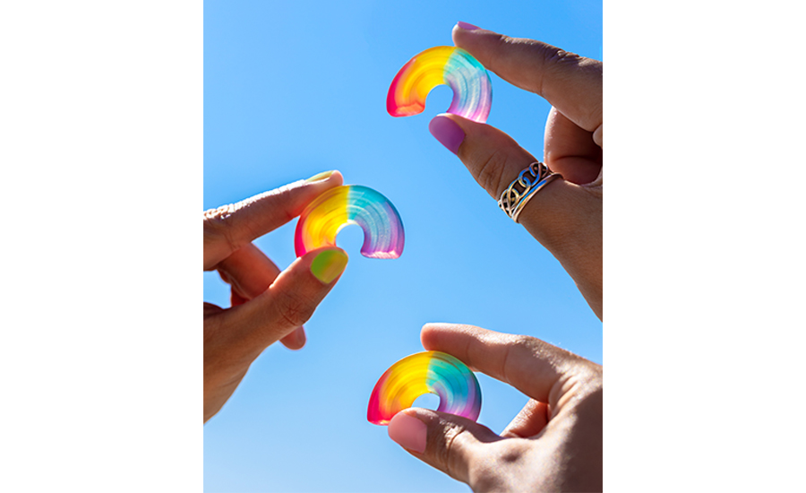 people holding rainbow themed plant based gummy candy