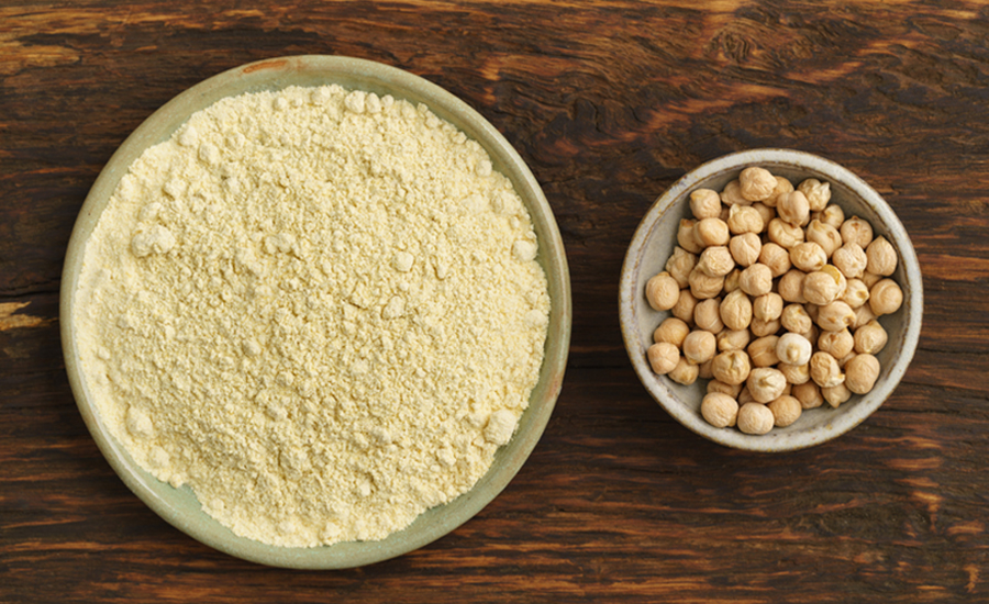 Large plate of chickpea flour next to smaller bowl of chickpeas