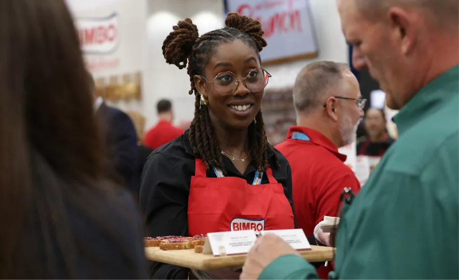 A woman representing Bimbo Bakeries offers samples to IDDBA attendees.