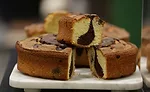 A cake with chocolate in the middle of it and with a brown crust.