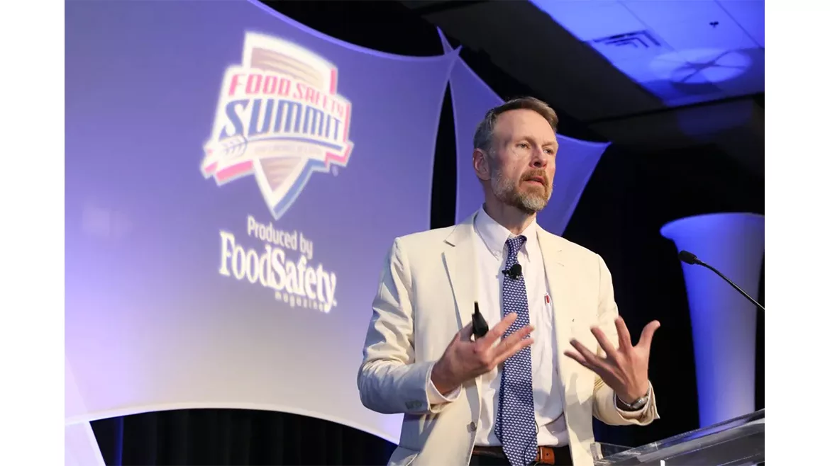 a speaker presenting at a conference focused on food safety protocols and industry advancements.