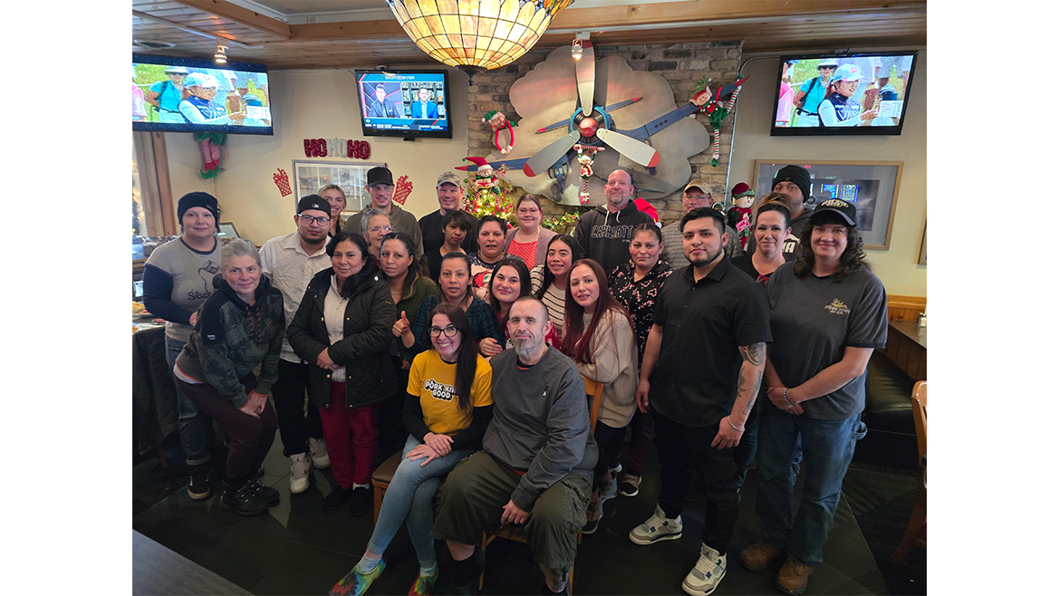 Mixed group of people with Pork King Good founders Lauren and Rick Koston in front